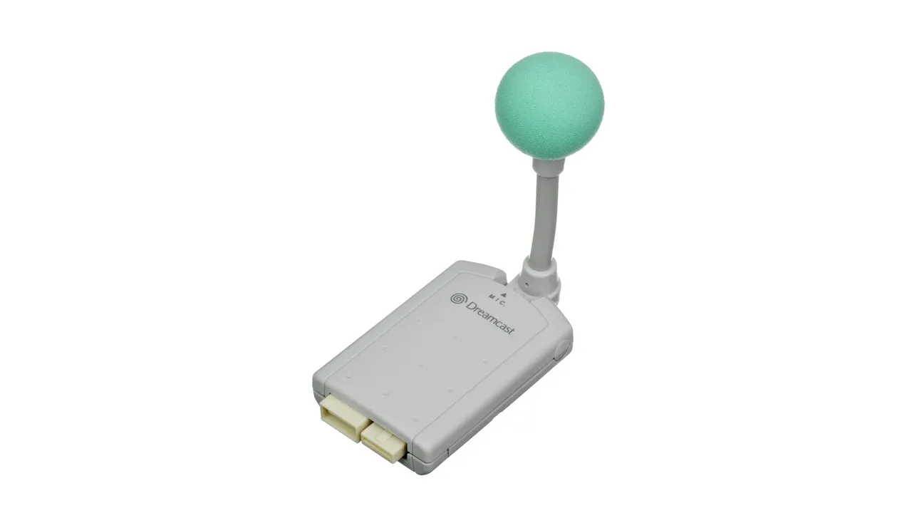 Sega Dreamcast microphone peripheral on white studio background — grey gooseneck base with mint-green foam windscreen; the Seaman voice-input accessory.