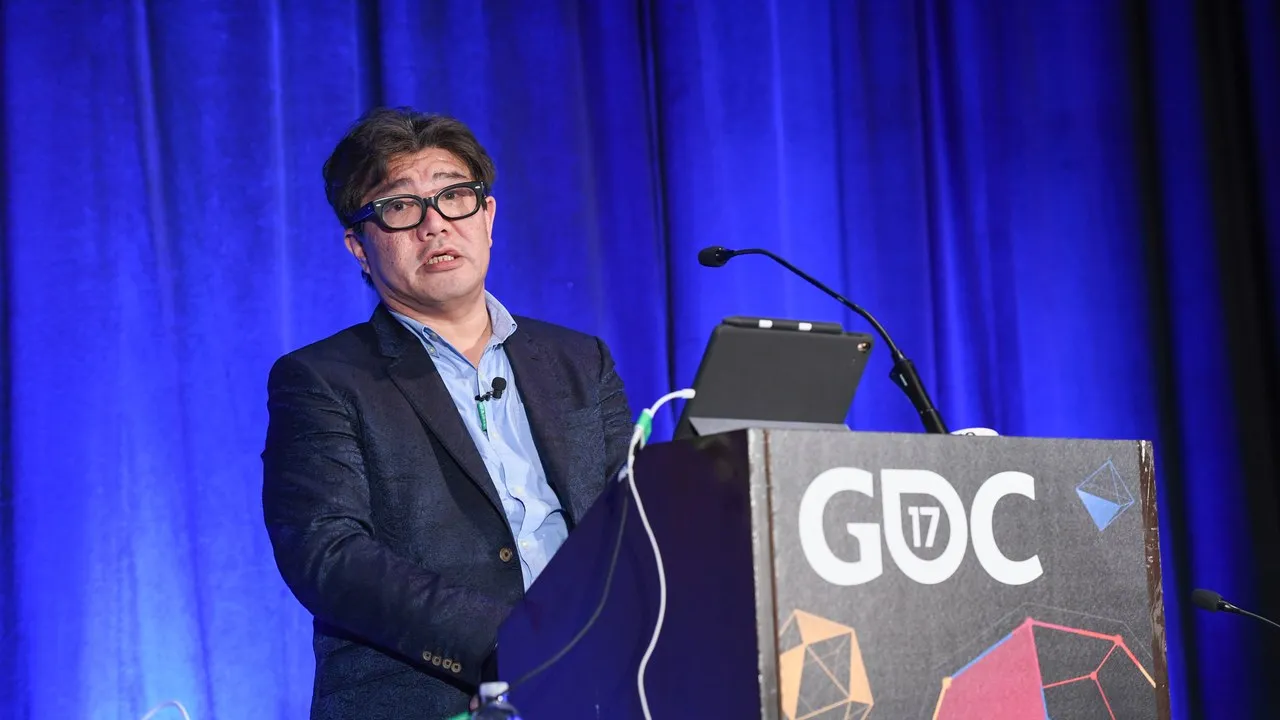 Yoot Saito speaking at a podium during GDC 2017 Seaman post-mortem; GDC 17 branding on lectern, blue stage curtain.