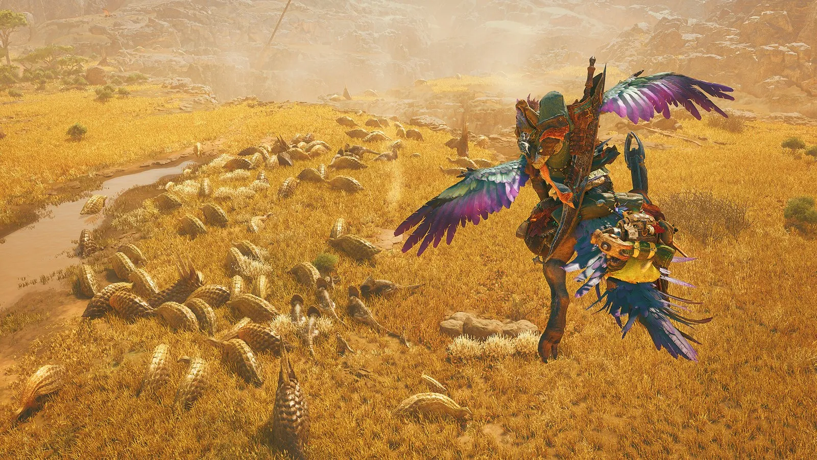 Monster Hunter Wilds screenshot from the existing PC release: a hunter in feathered armor rides a purple-winged mount across golden savanna past a herd of small armored creatures.